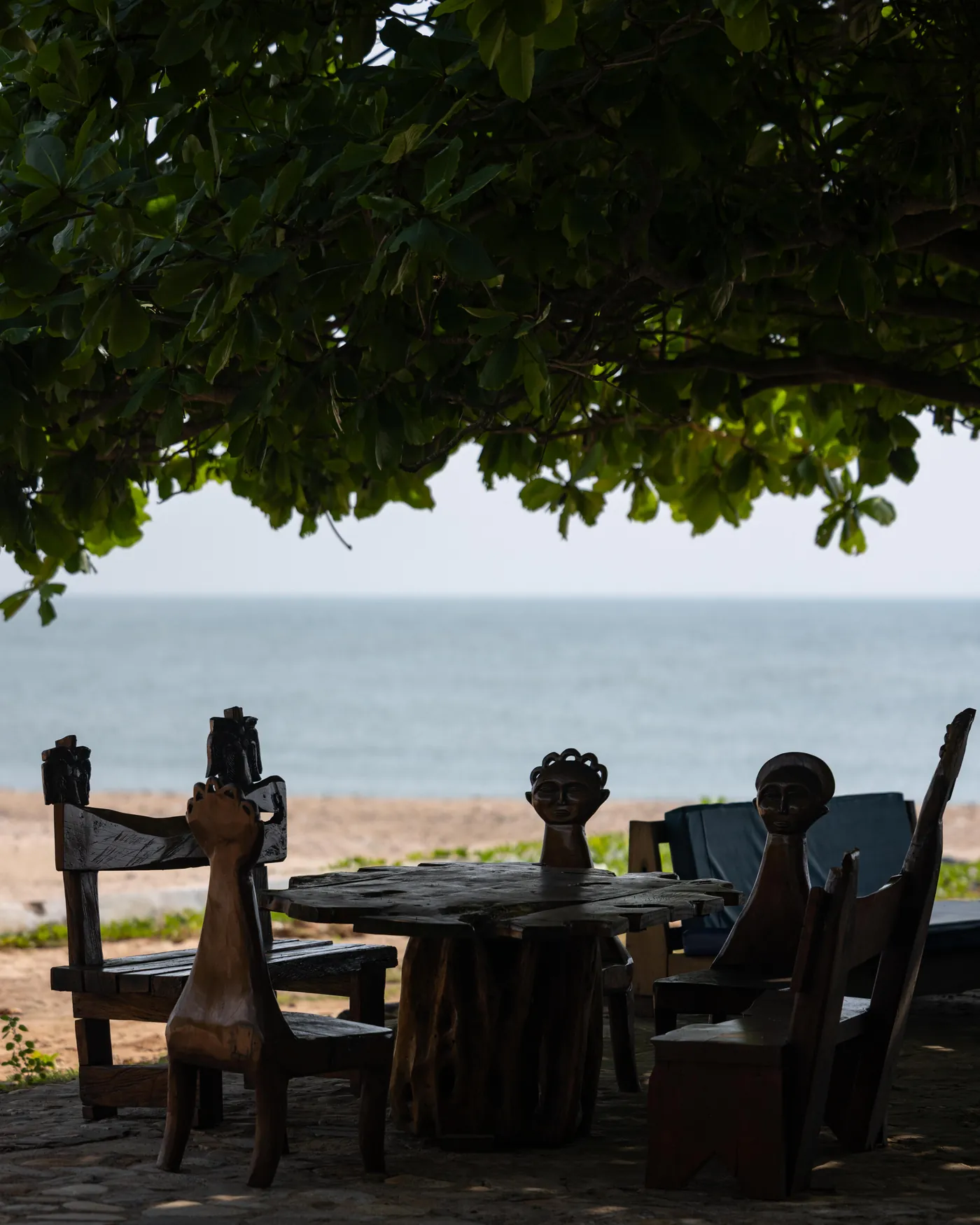 A table set under the trees looking straight out at the water