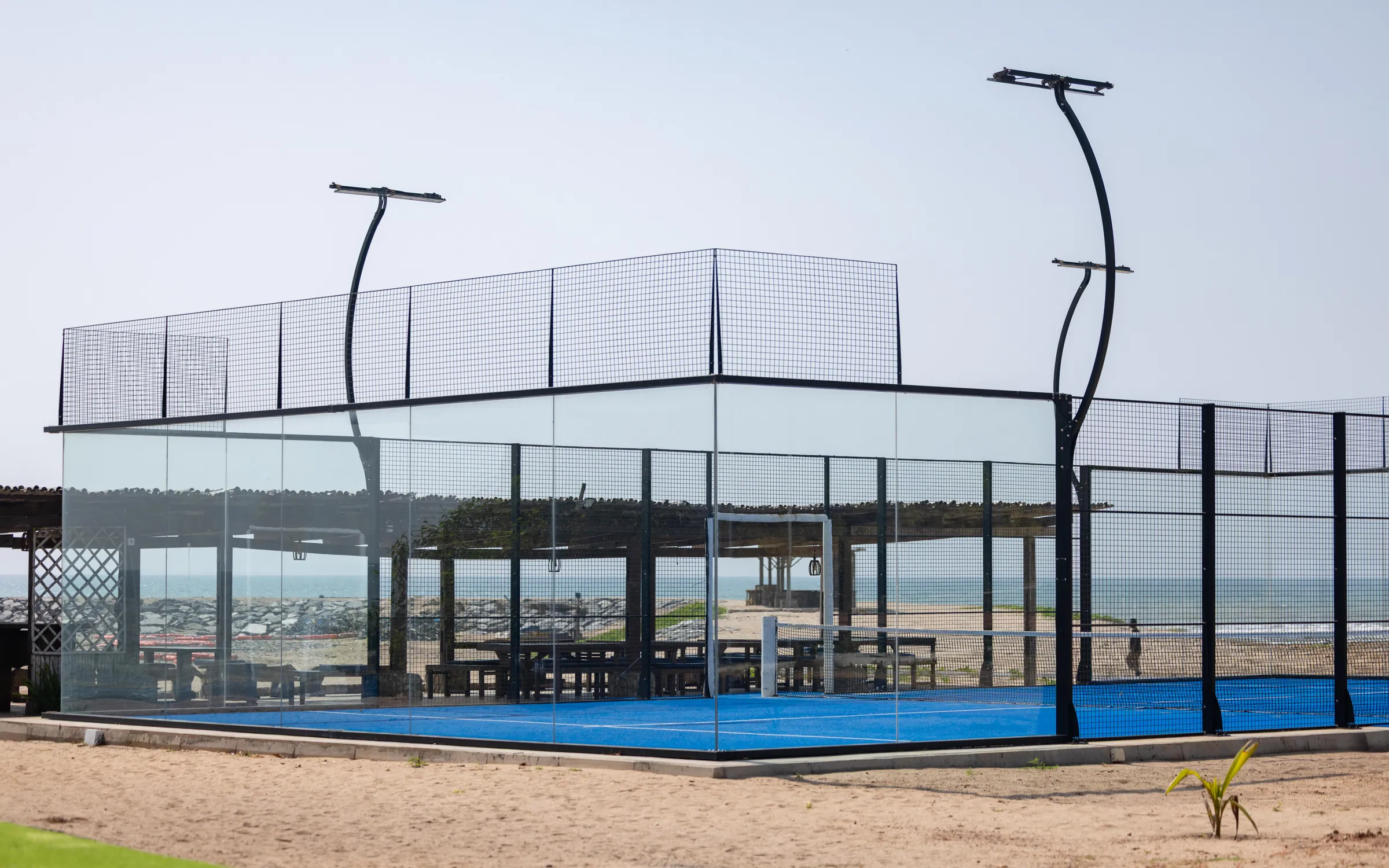 The glass padel court beside the beach