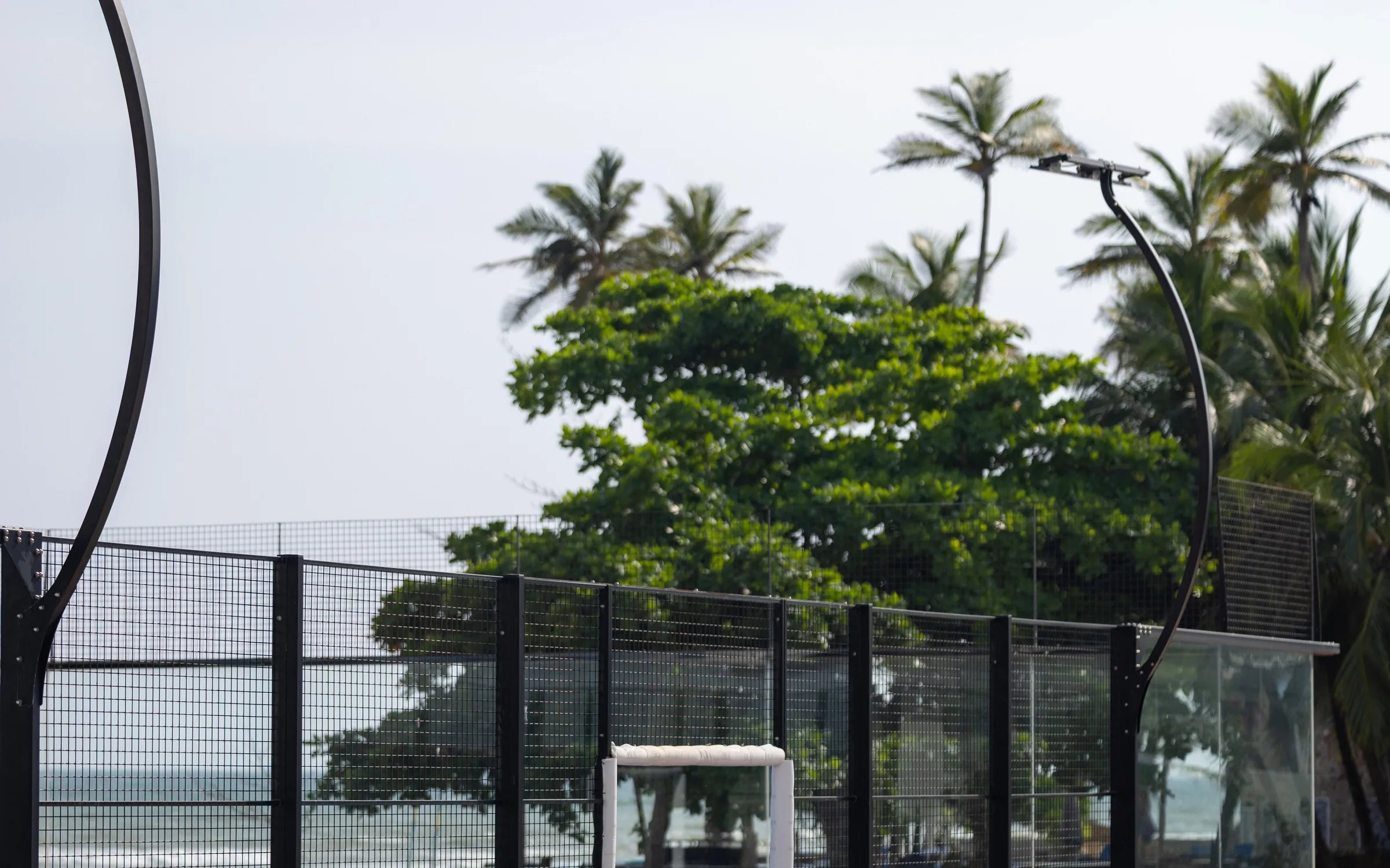 The court by the sea, the water beyond the fence
