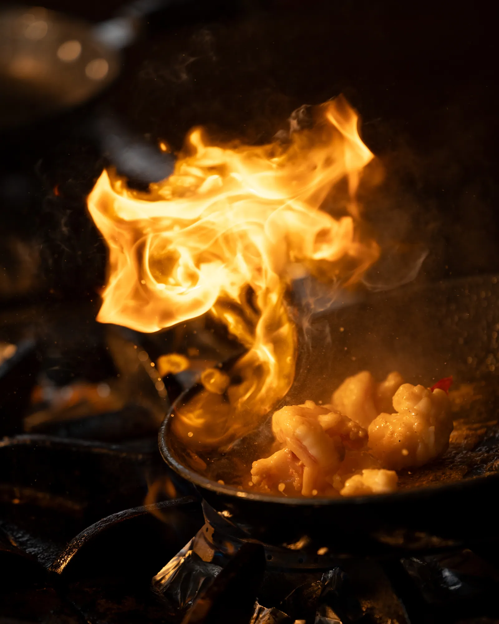 Open flame rising from the pan over the fire